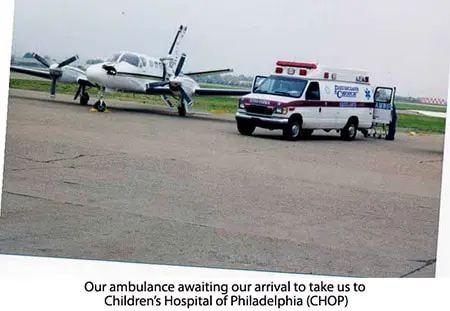 A small airplane and ambulance on the tarmac.