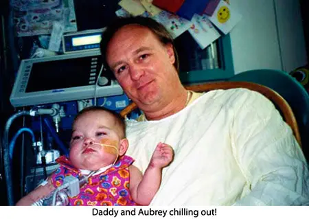A man and child in hospital bed with the caption " daddy and aubrey chilling out ".