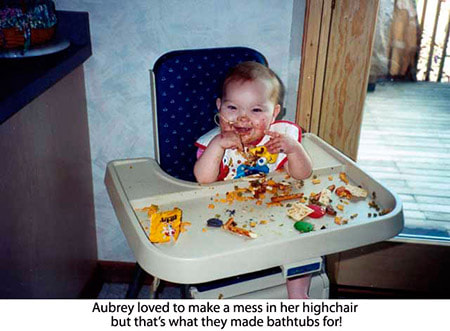 A baby sitting in a high chair with many toys.